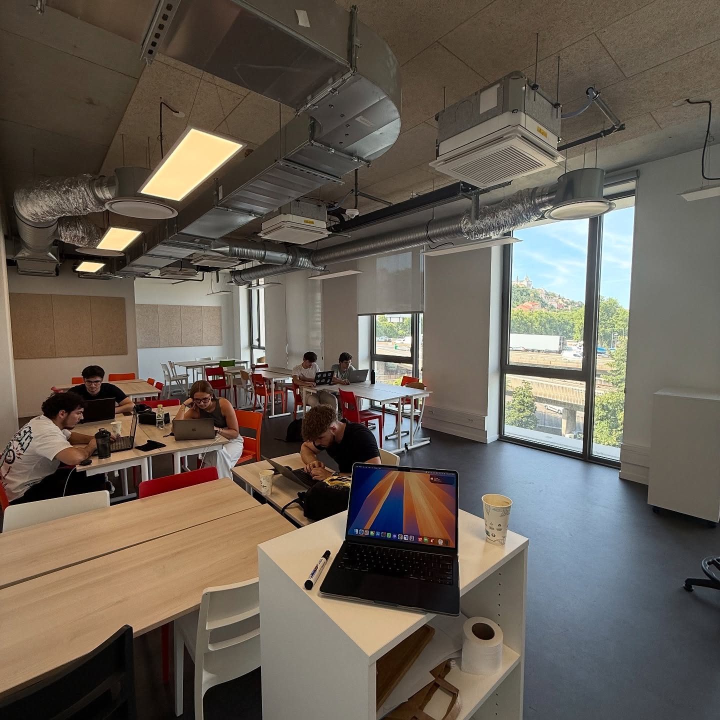 Students working at laptops in the YNOV classroom