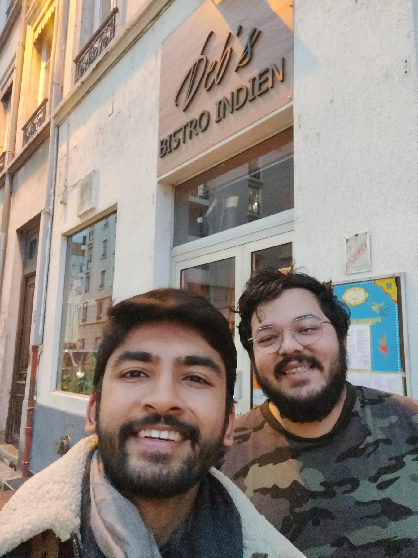 Manan Mehta and a restaurant founder outside Deb's Bistro Indien in Lyon