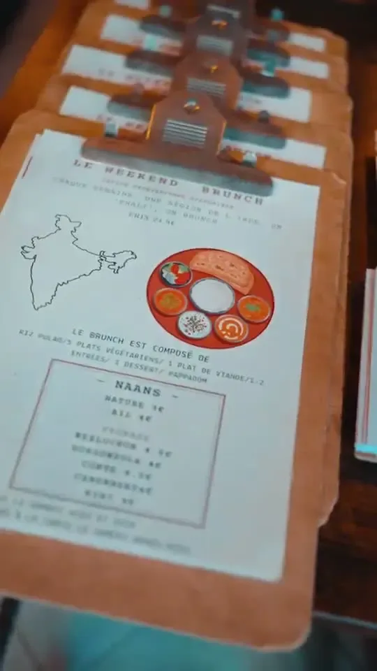 A printed restaurant menu on a wooden clipboard, with a map of India on the cover