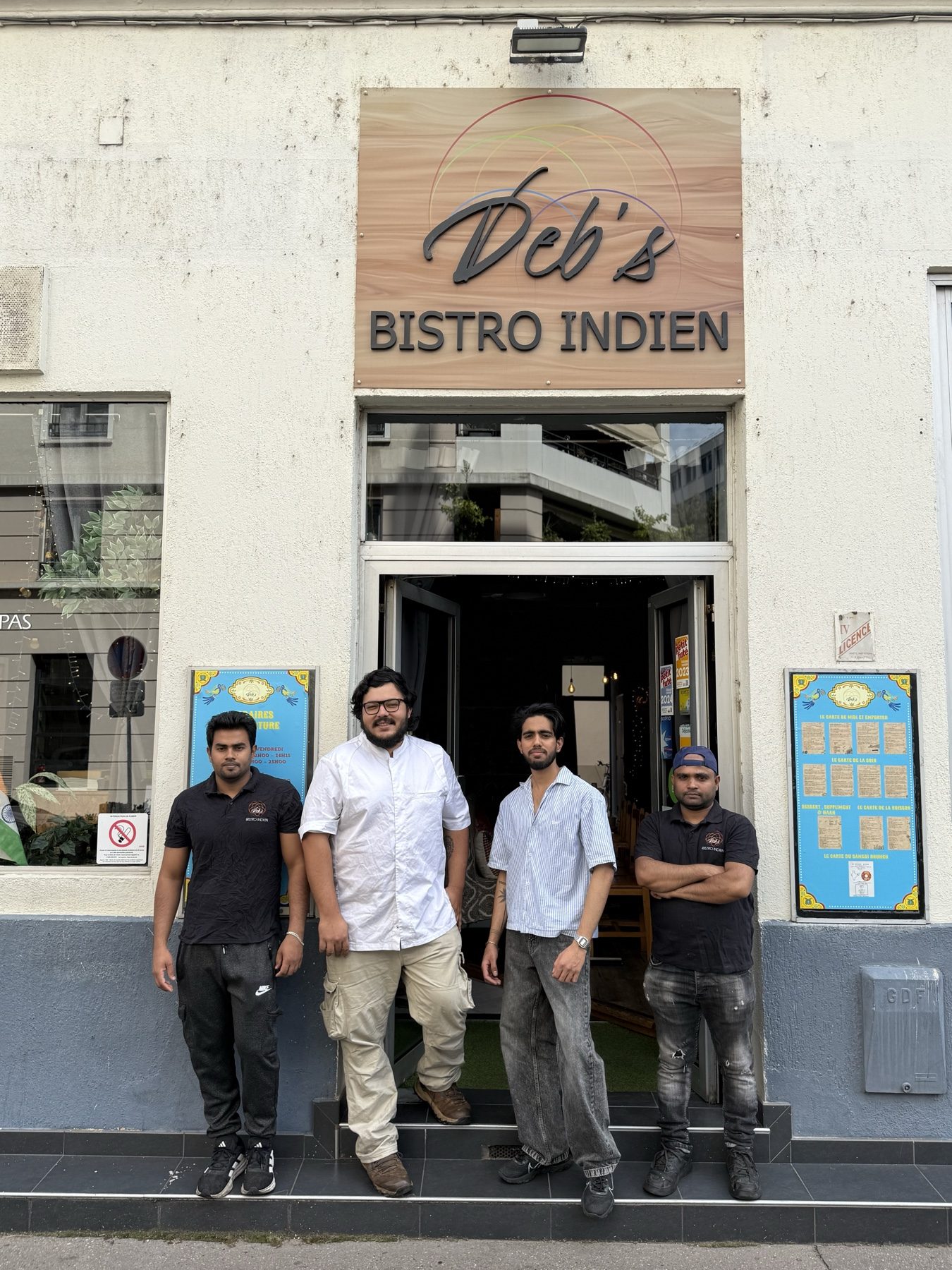 Four members of the restaurant team standing outside the Deb's Bistro Indien shopfront in Lyon