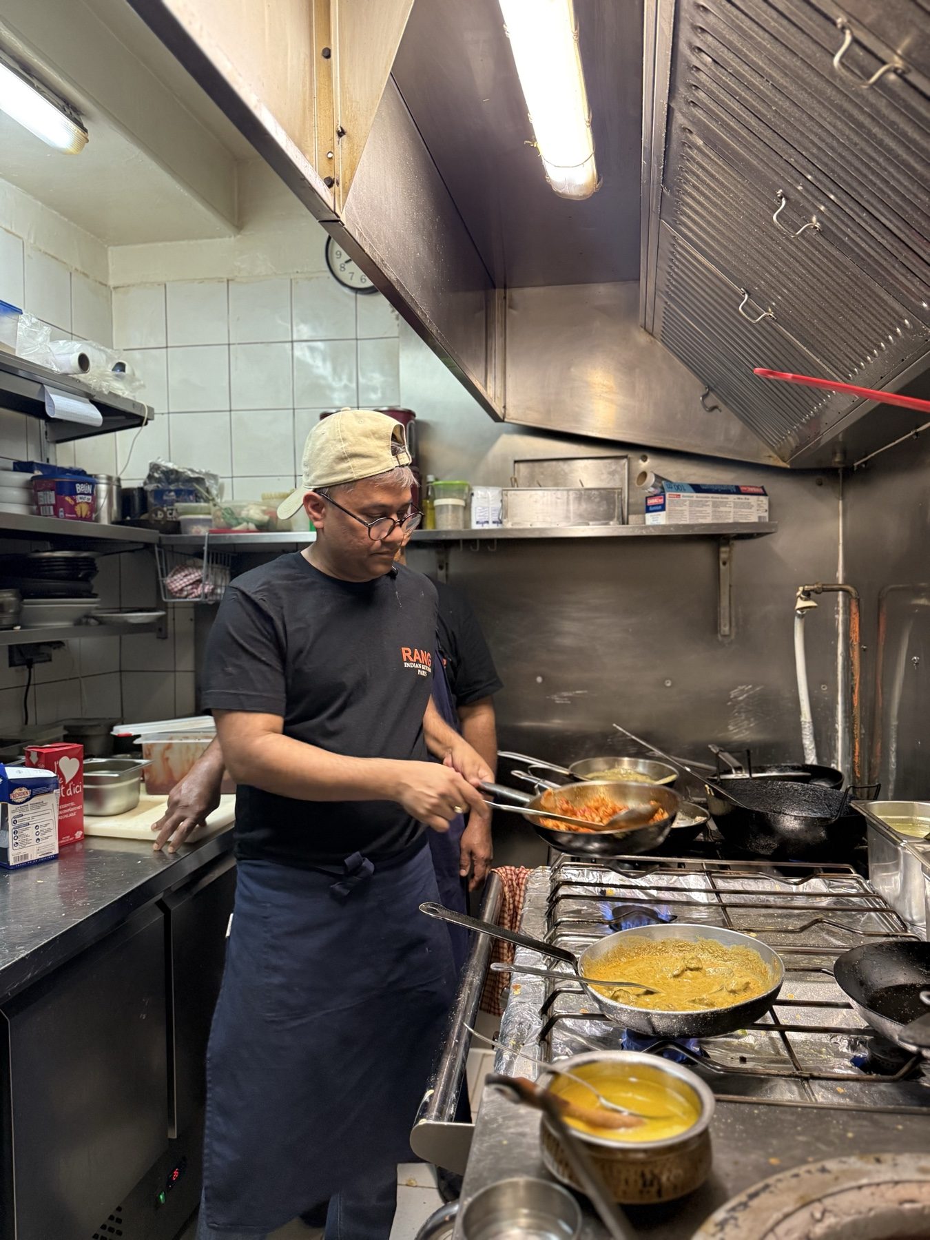 A chef cooking on the line in an Indian restaurant kitchen in France