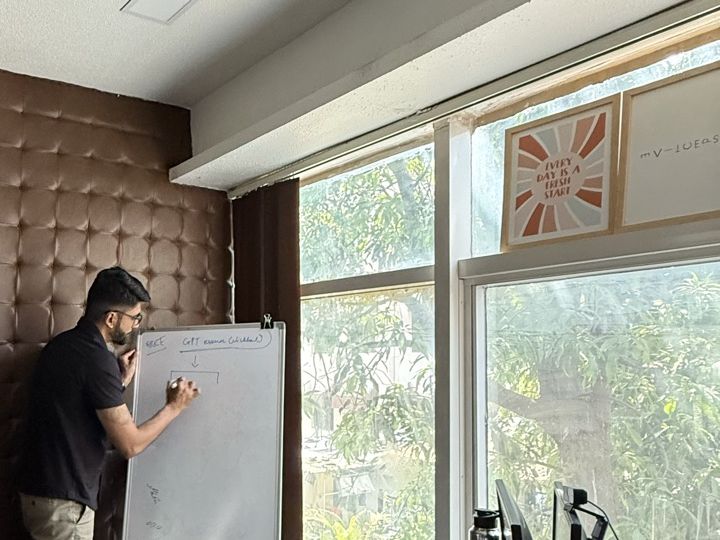 Manan Mehta writing a funnel on a whiteboard in the Mumbai office
