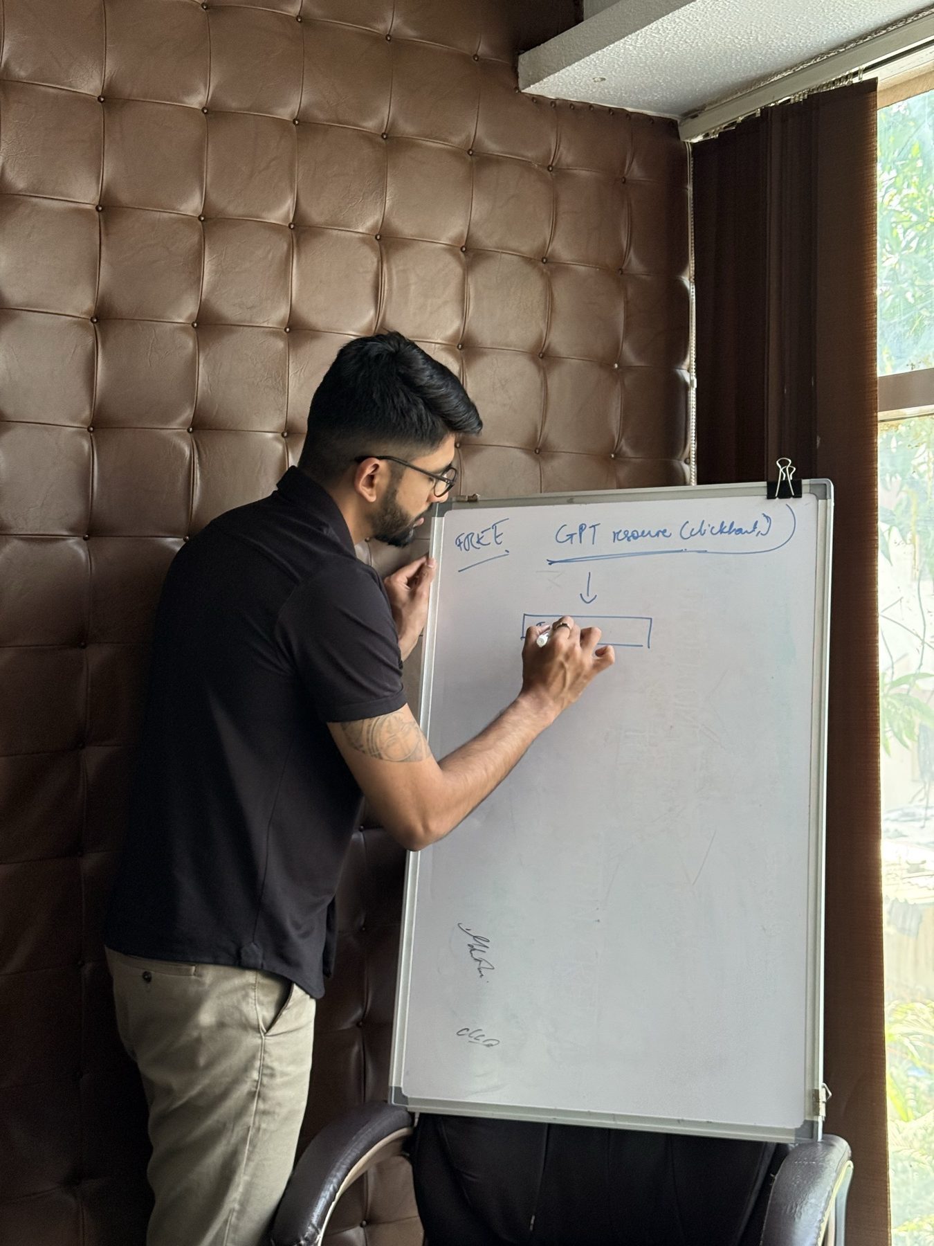 Manan Mehta writing on a whiteboard in the Mumbai office