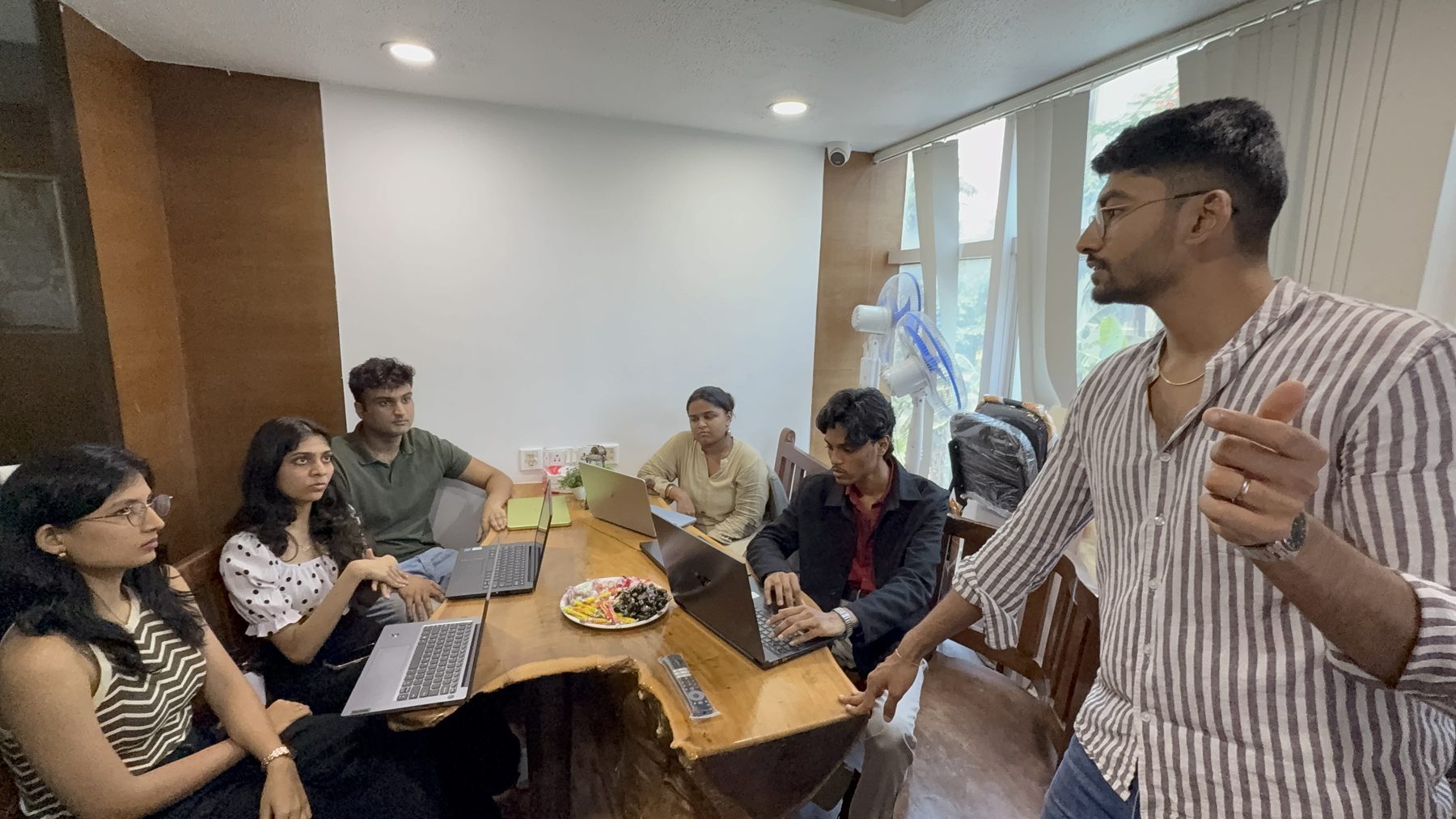 Manan Mehta leading a marketing workshop at a table with six participants
