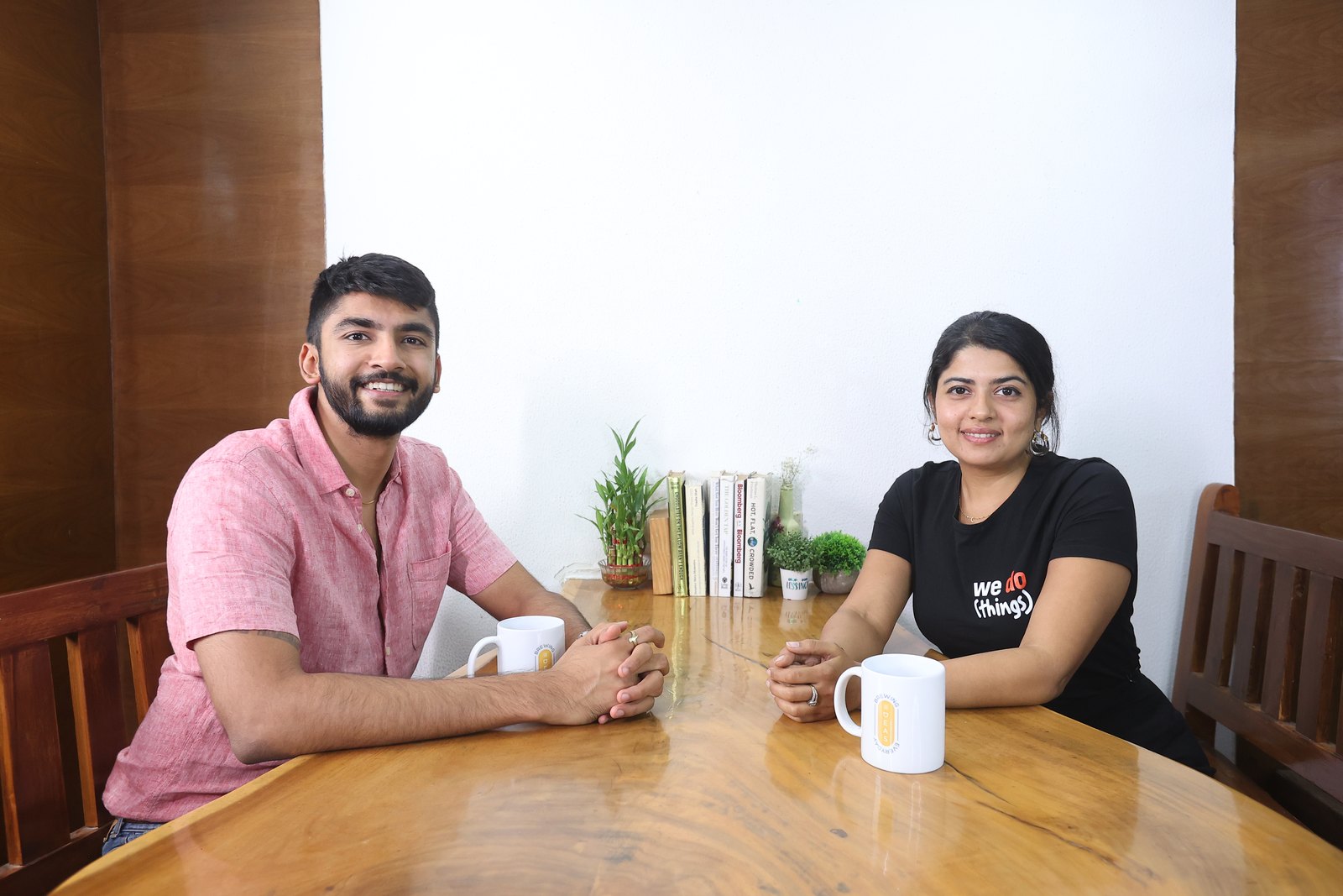 Manan Mehta in conversation with a colleague across a table in the office