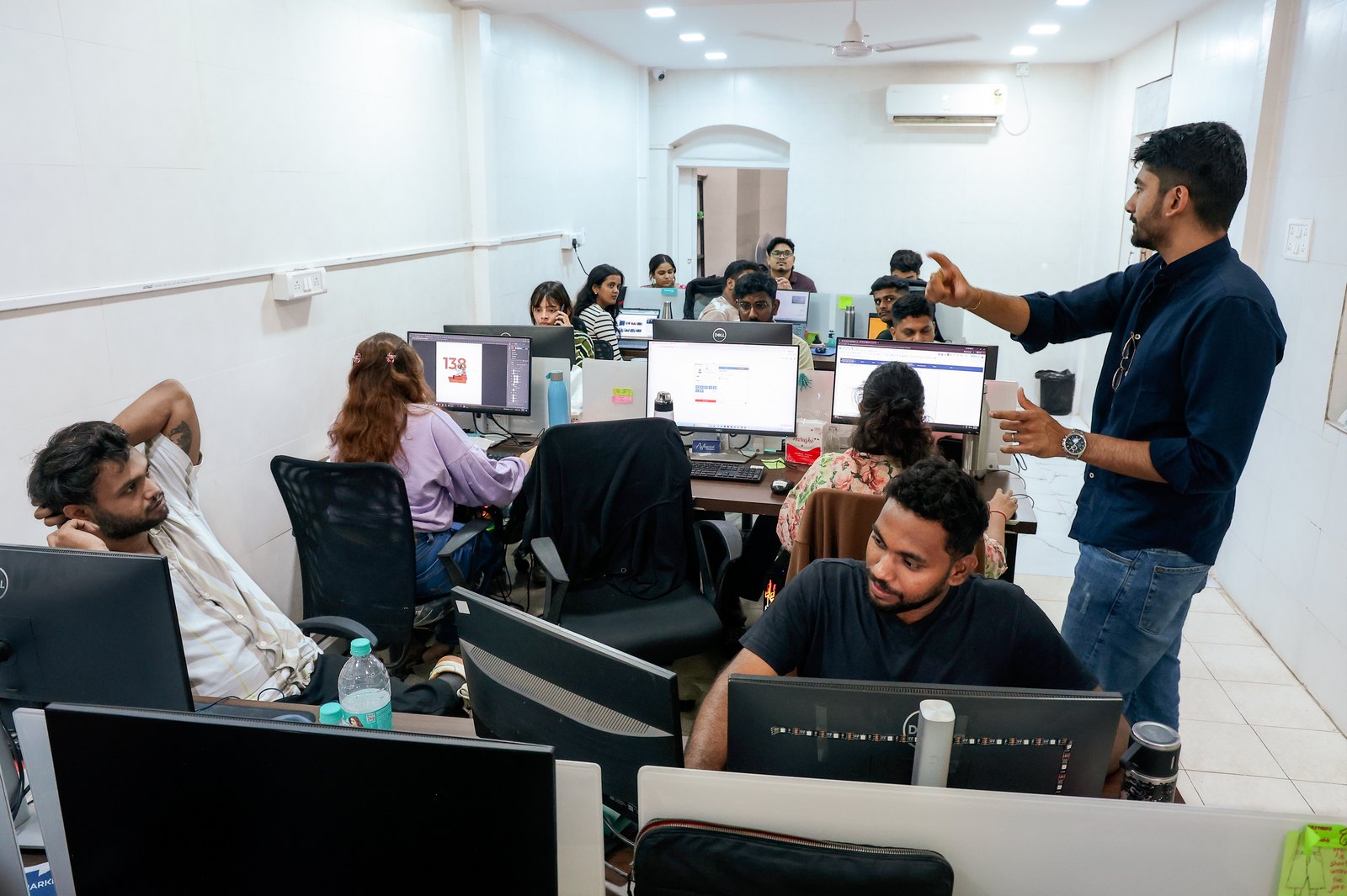 Manan Mehta reviewing work with the team at their monitors in the Mumbai office