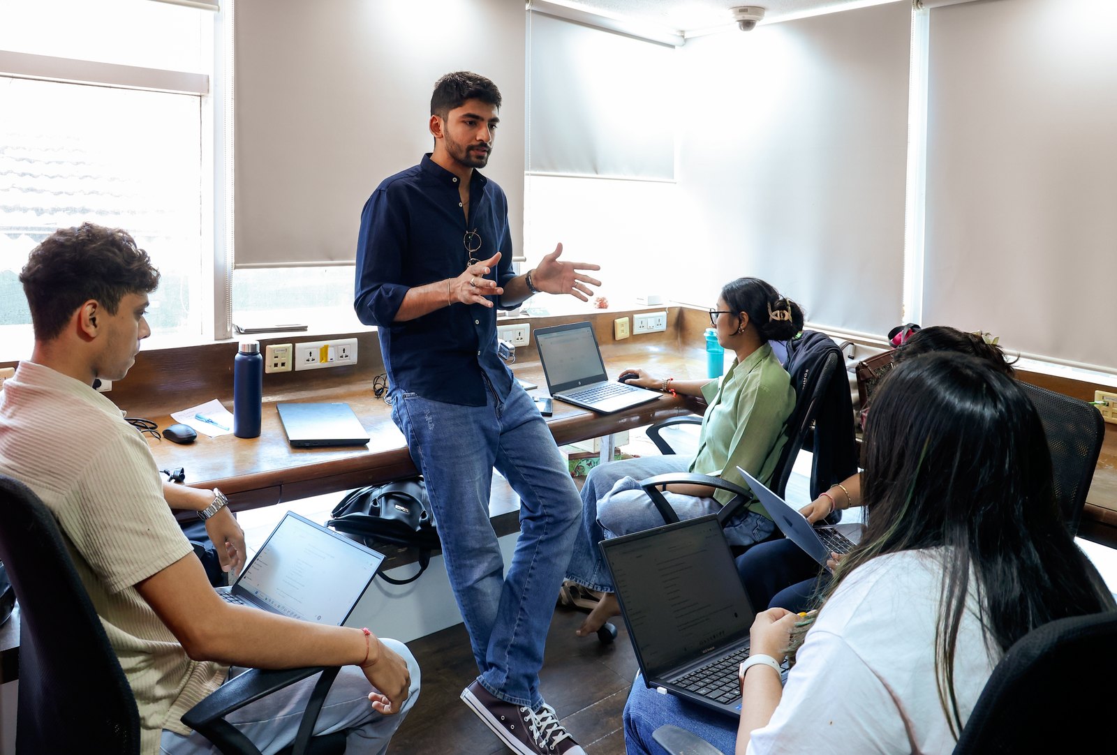Manan Mehta talking with the MarketinCrew team at their desks in the Mumbai office