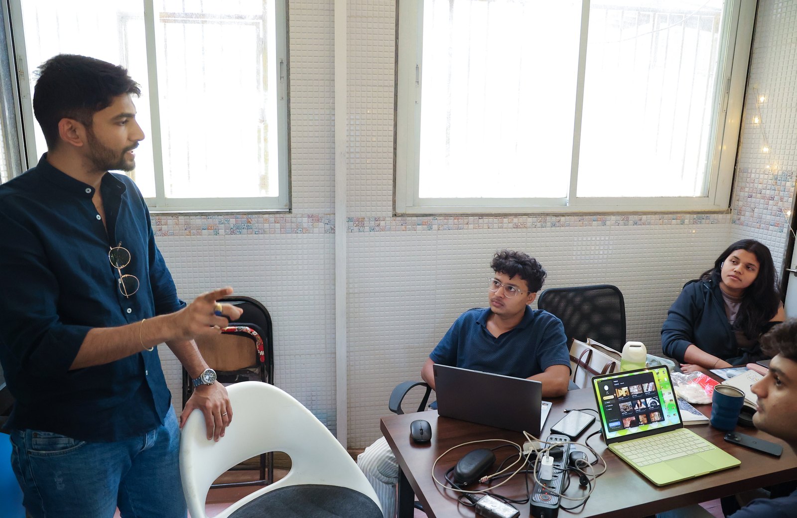 Manan Mehta explaining a plan to two members of the team at their desks